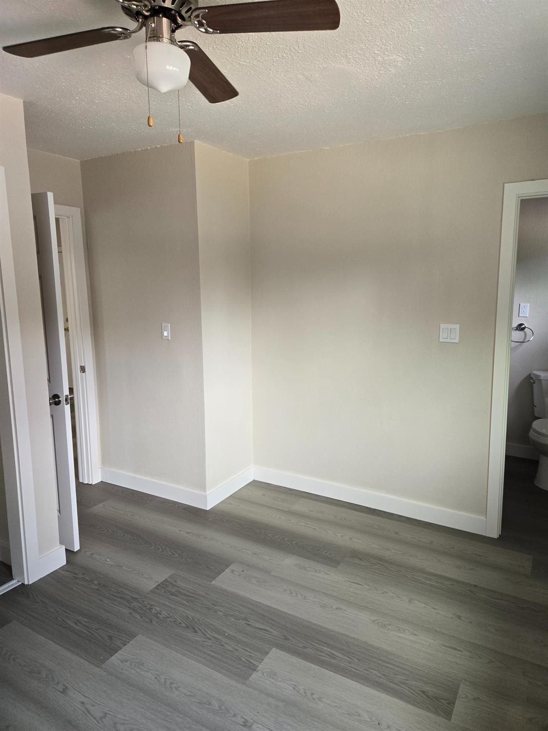 1036 North Sutter Street, Unit 5 Stockton, CA 95202 - Photo 6 of 10 a view of a room with wooden floor and a ceiling fan