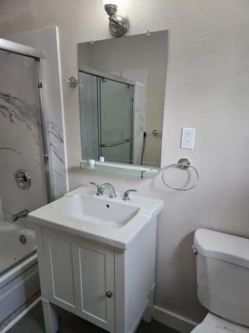 a bathroom with a sink toilet and mirror