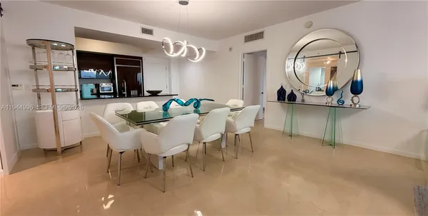 a view of a dining room with furniture and a chandelier