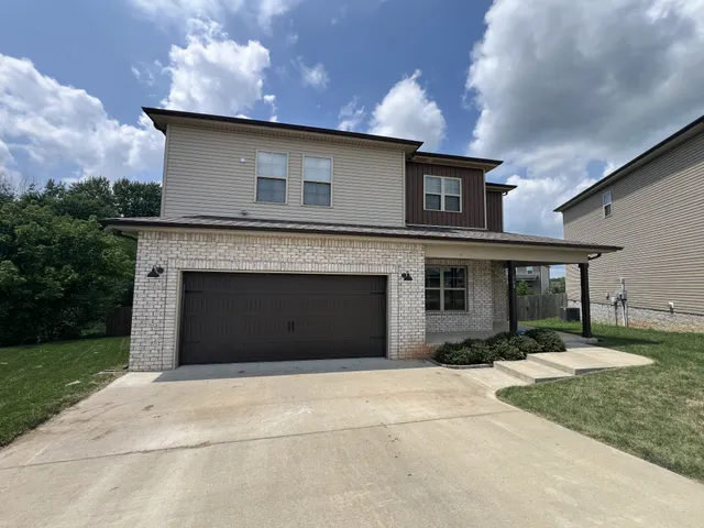 a front view of a house with a yard and garage