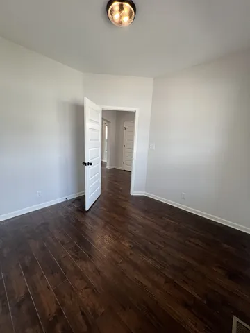 an empty room with windows fireplace and wooden floor