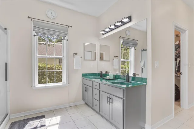 a bathroom with a granite countertop sink a mirror and a window
