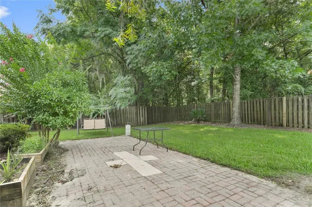 a view of a yard with plants and trees