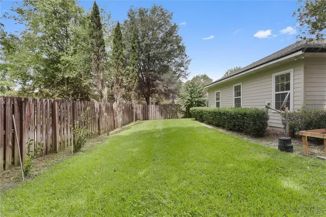 a backyard of a house with plants and tree
