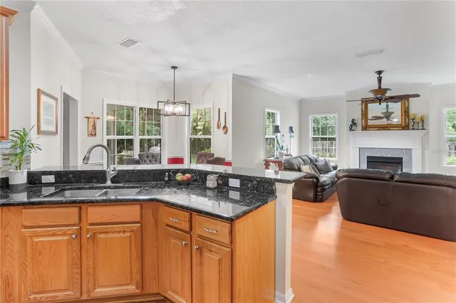 a kitchen with granite countertop a stove a sink dishwasher and cabinets with wooden floor