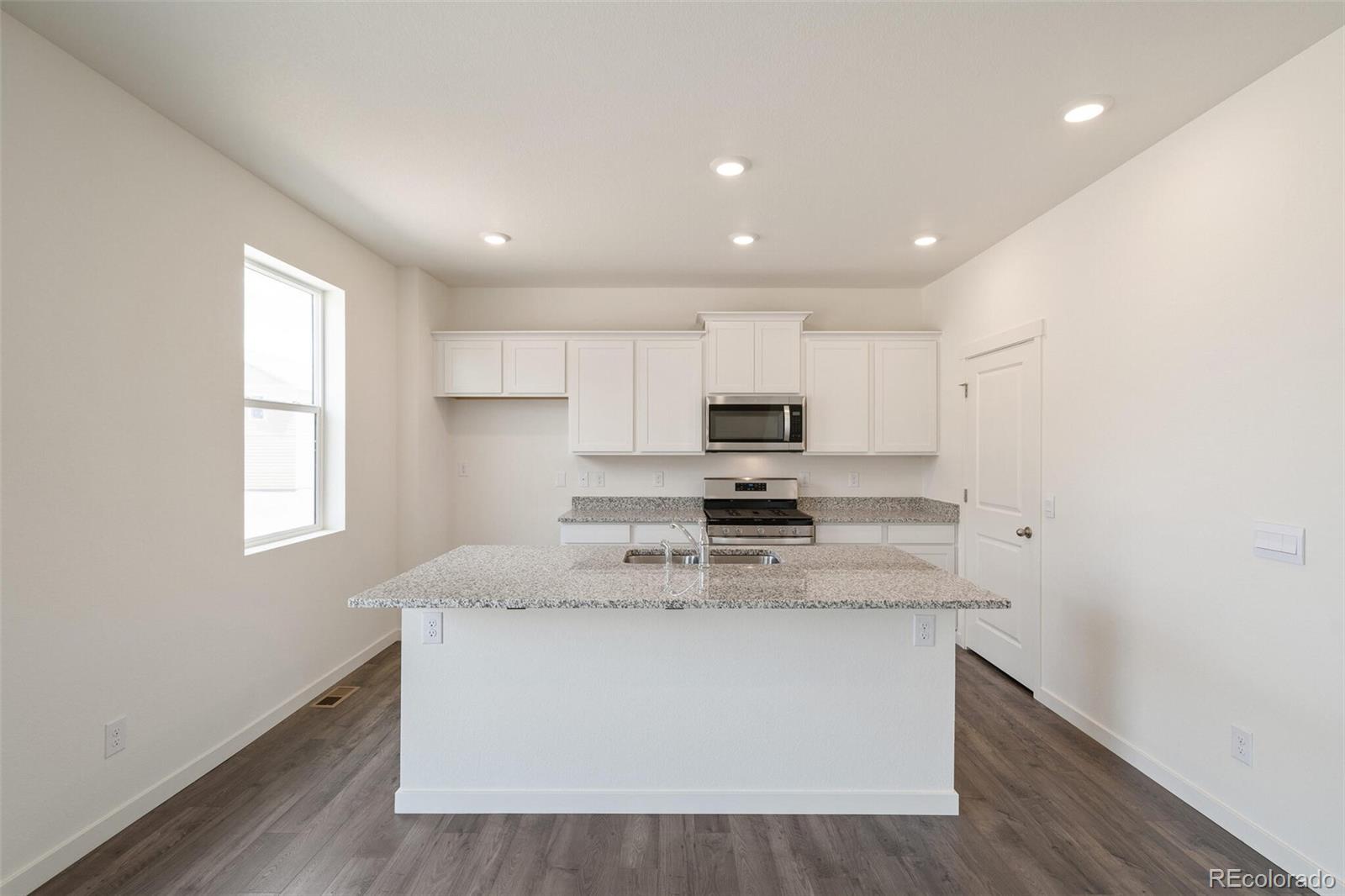 219 Haymaker Lane Severance, CO 80550 - Photo 11 of 44 a kitchen with kitchen island granite countertop a sink appliances cabinets and a counter top space
