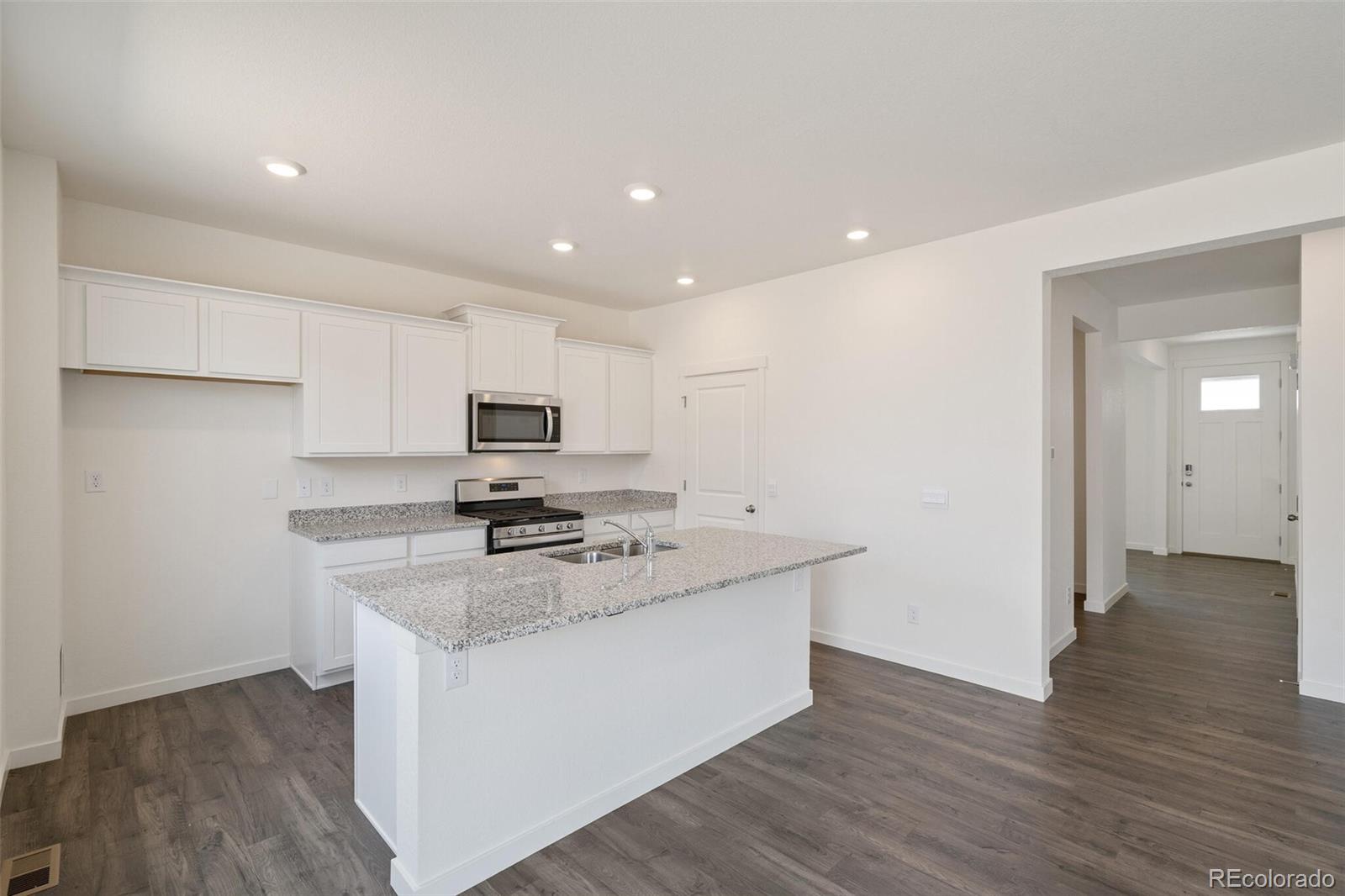 219 Haymaker Lane Severance, CO 80550 - Photo 12 of 44 a kitchen with stainless steel appliances granite countertop a sink stove and refrigerator
