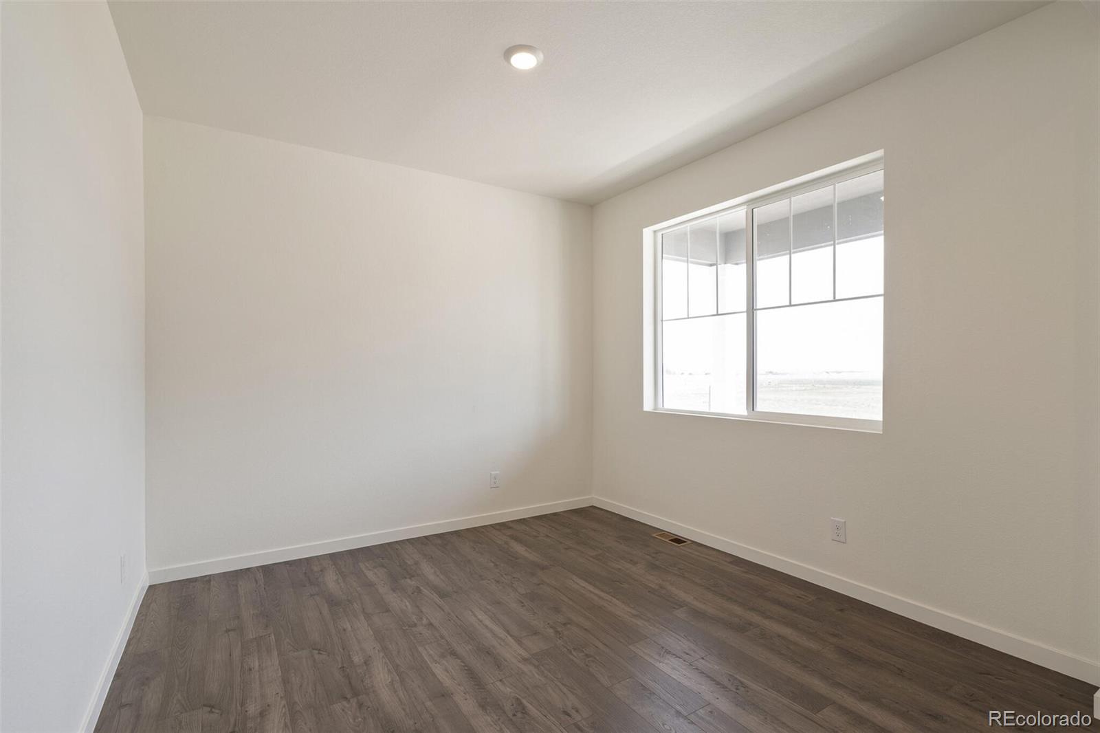 219 Haymaker Lane Severance, CO 80550 - Photo 16 of 44 an empty room with wooden floor and windows