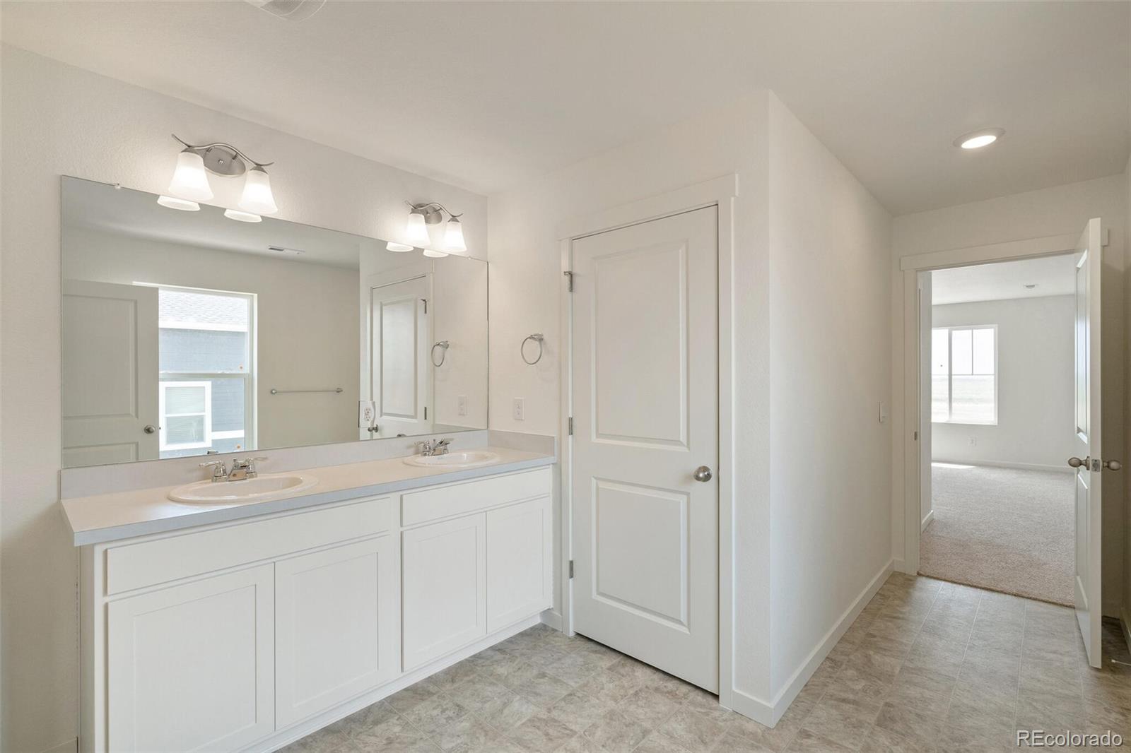 219 Haymaker Lane Severance, CO 80550 - Photo 23 of 44 a bathroom with a double vanity sink and mirror
