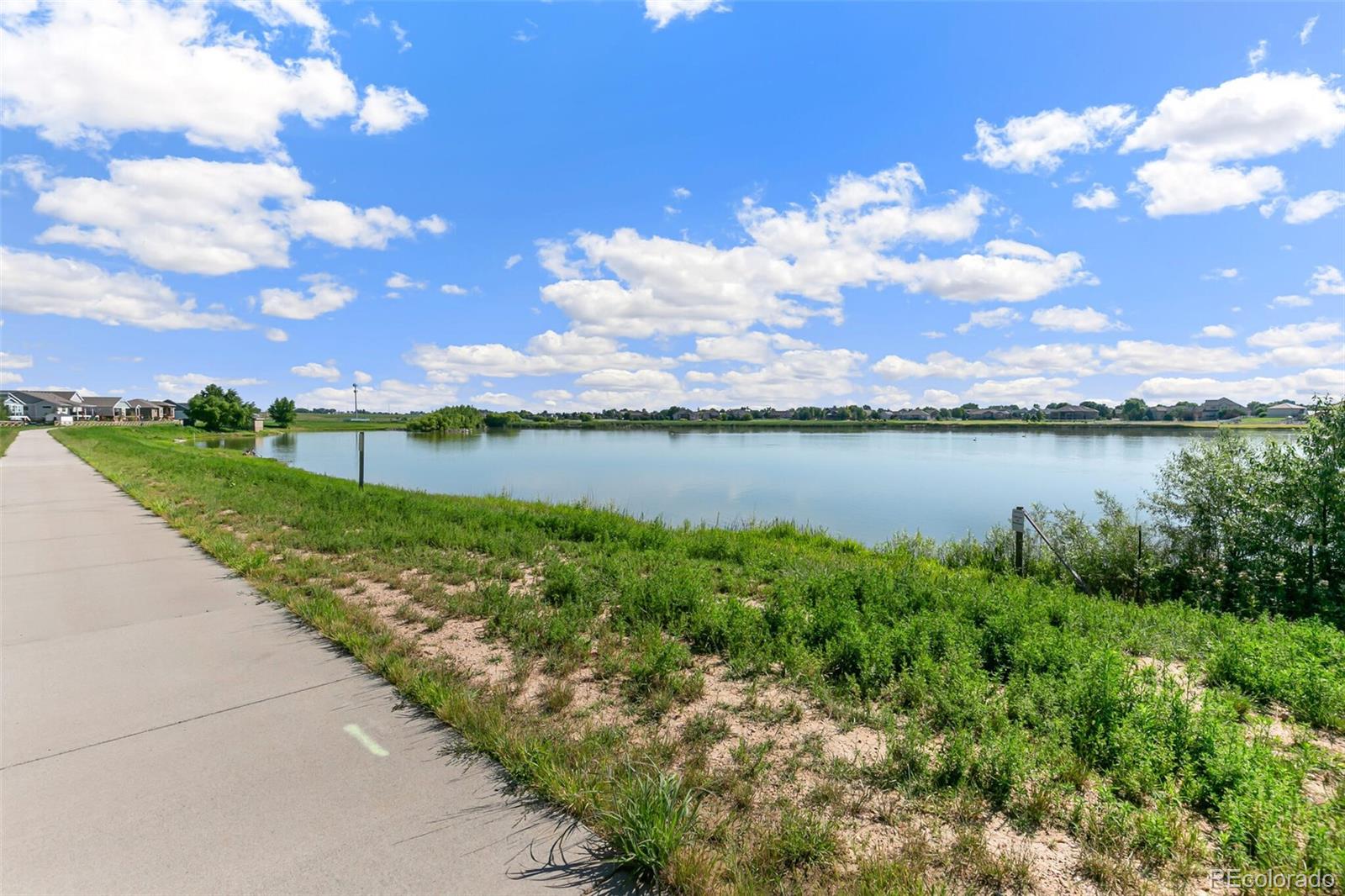 219 Haymaker Lane Severance, CO 80550 - Photo 36 of 44 a view of a lake with houses in the back