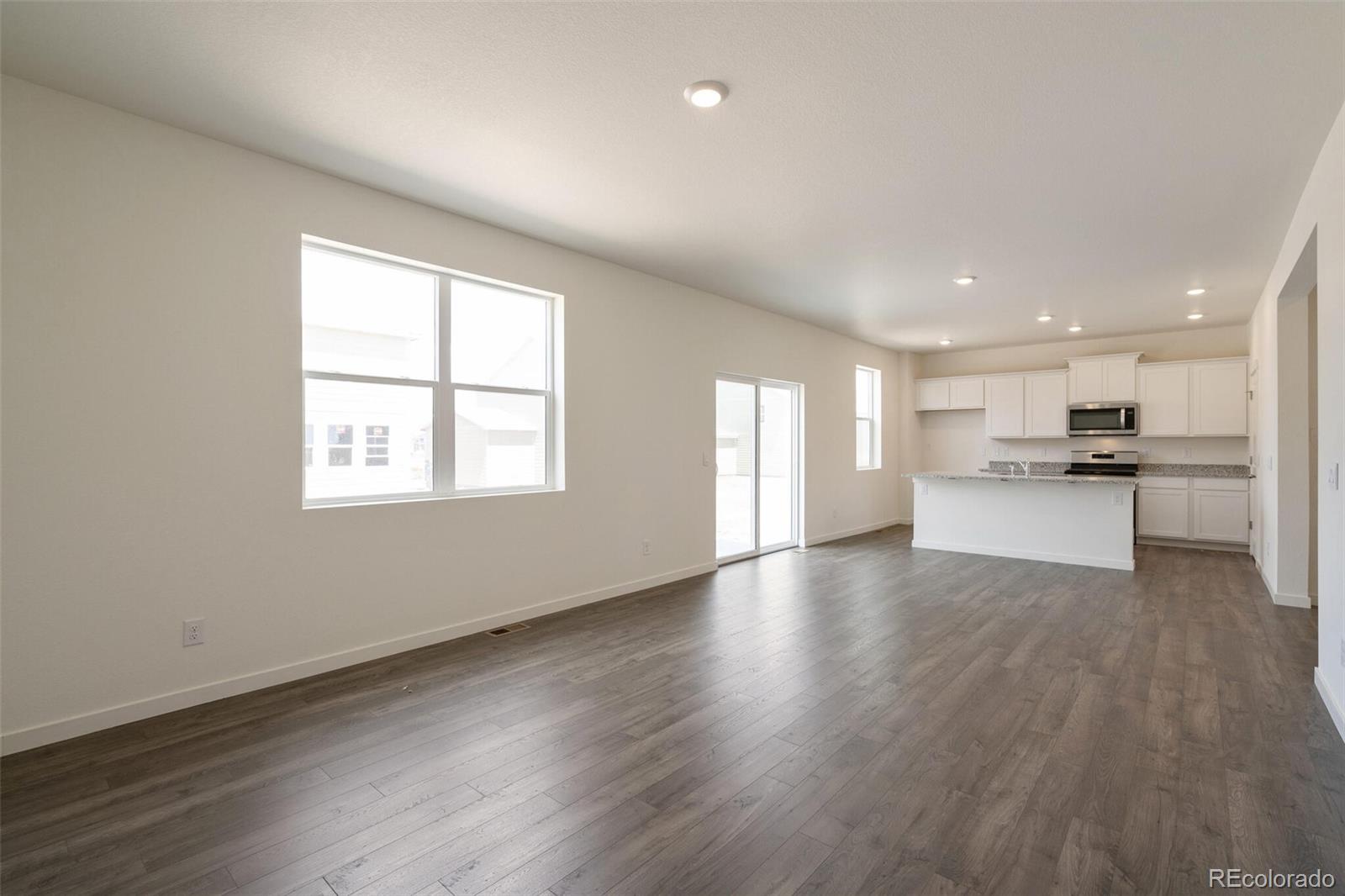 219 Haymaker Lane Severance, CO 80550 - Photo 5 of 44 a view of kitchen with wooden floor and windows