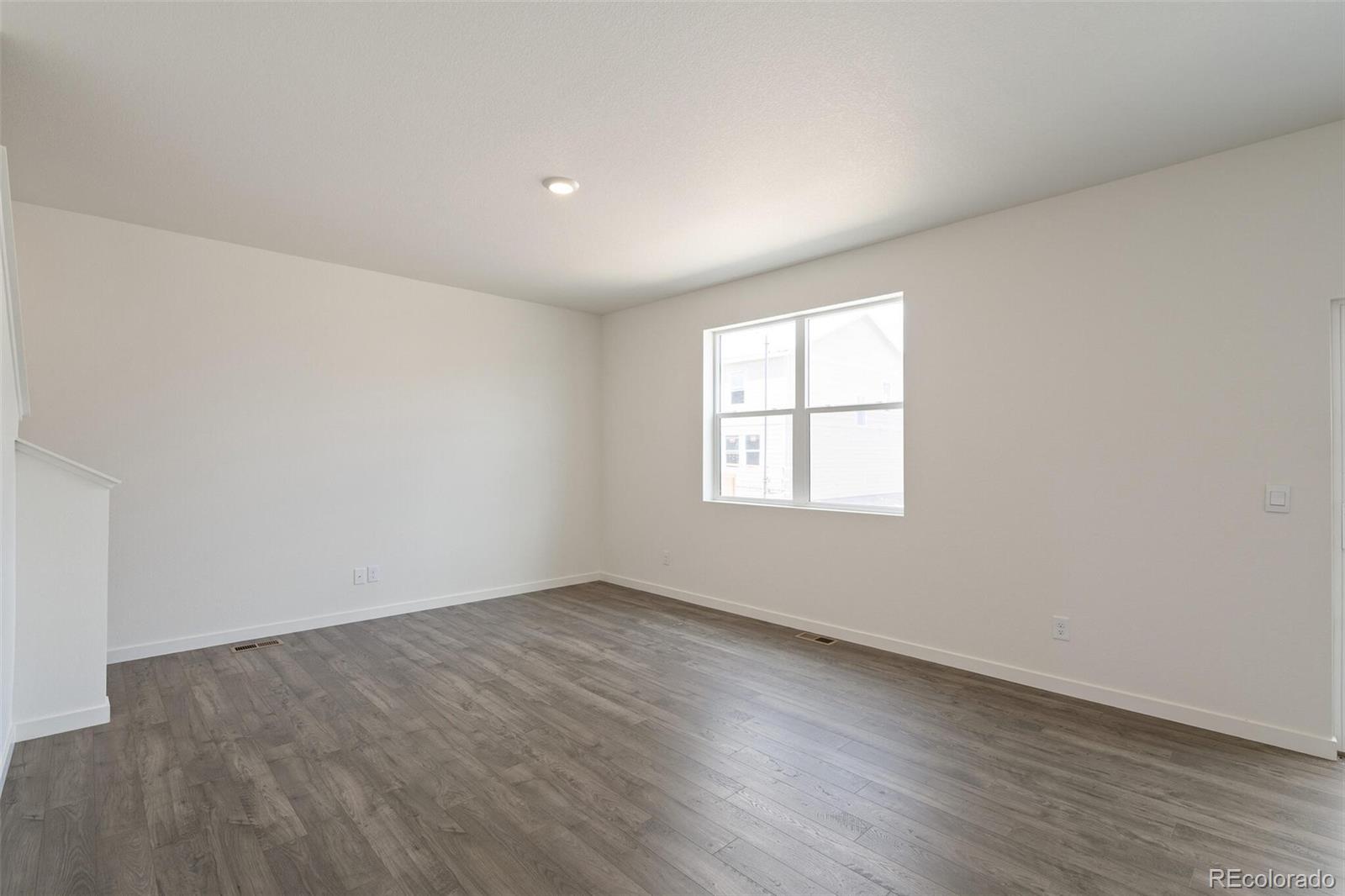 219 Haymaker Lane Severance, CO 80550 - Photo 7 of 44 an empty room with wooden floor and windows