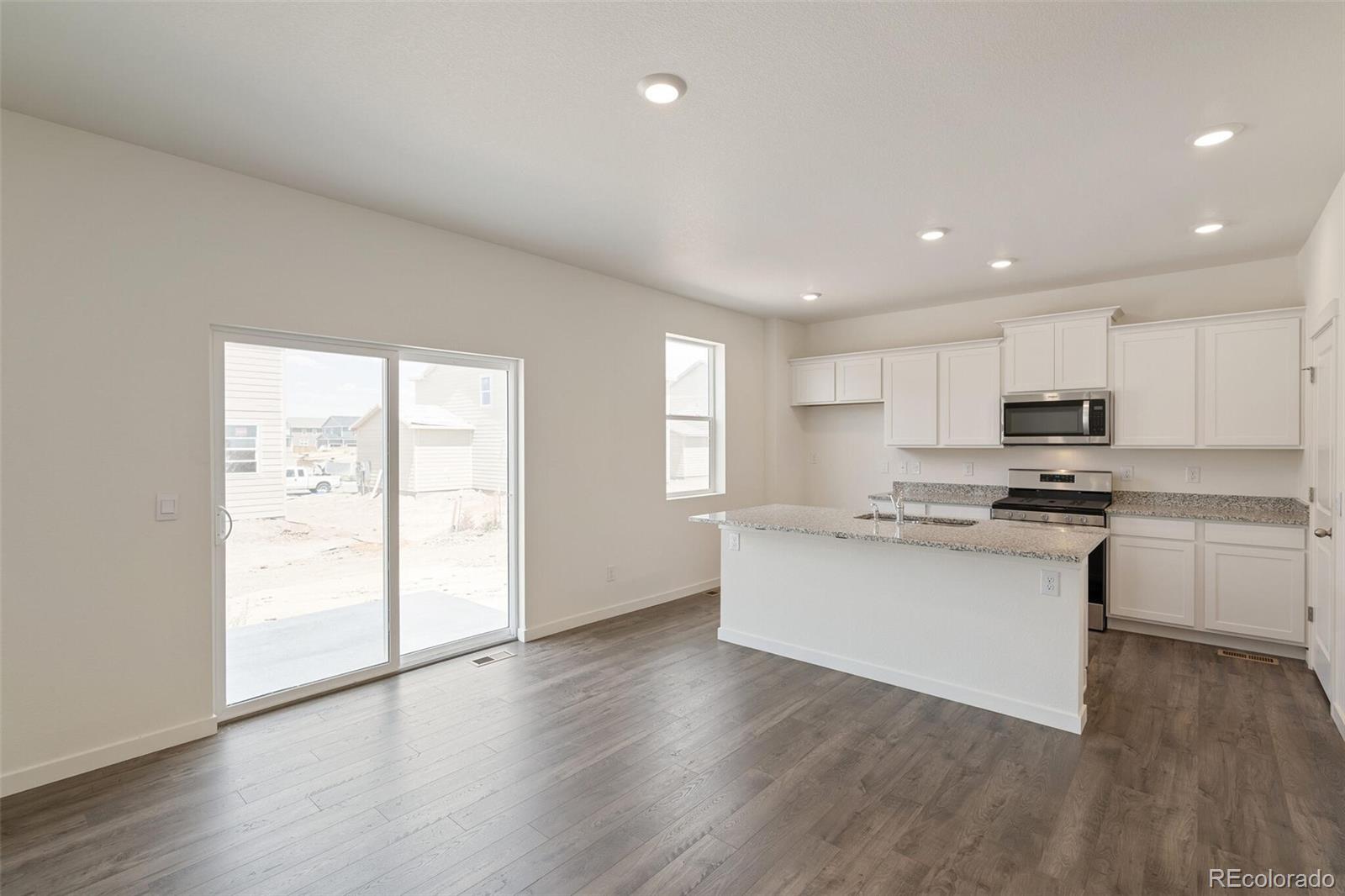 219 Haymaker Lane Severance, CO 80550 - Photo 9 of 44 a kitchen with stainless steel appliances granite countertop a stove and a refrigerator