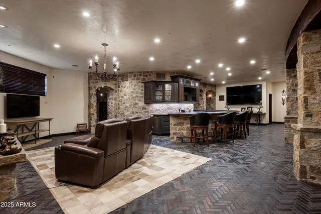 a living room with furniture a flat screen tv and kitchen view
