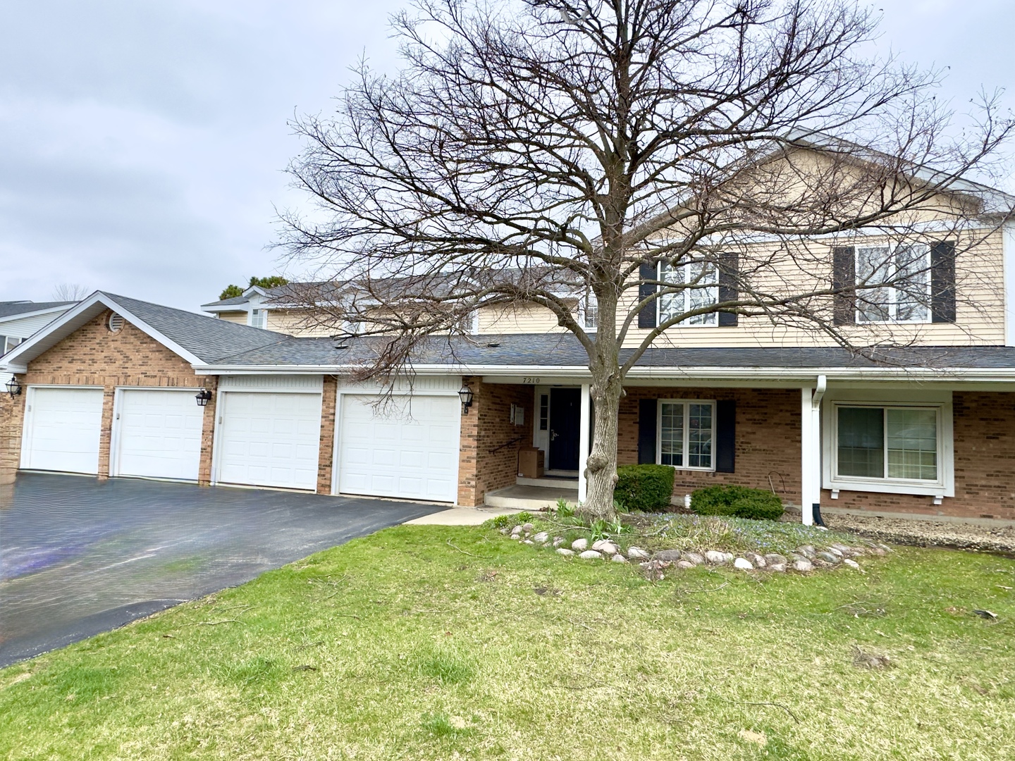 7210 Adams Street, Unit D Willowbrook, IL 60527 - Photo 1 of 19 a front view of a house with a yard and potted plants