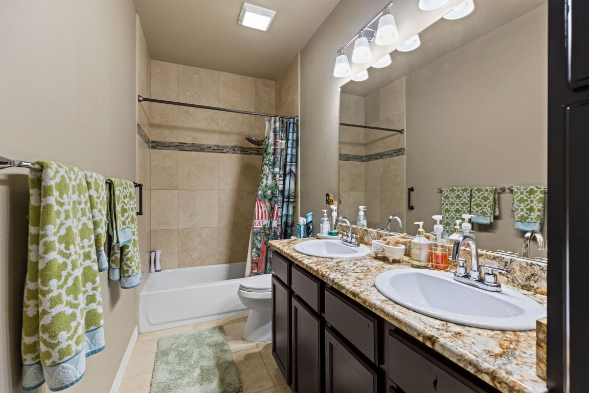 1291 Mossy Hollow Road Spring Branch, TX 78070 - Photo 13 of 23 a bathroom with a granite countertop sink a toilet and shower