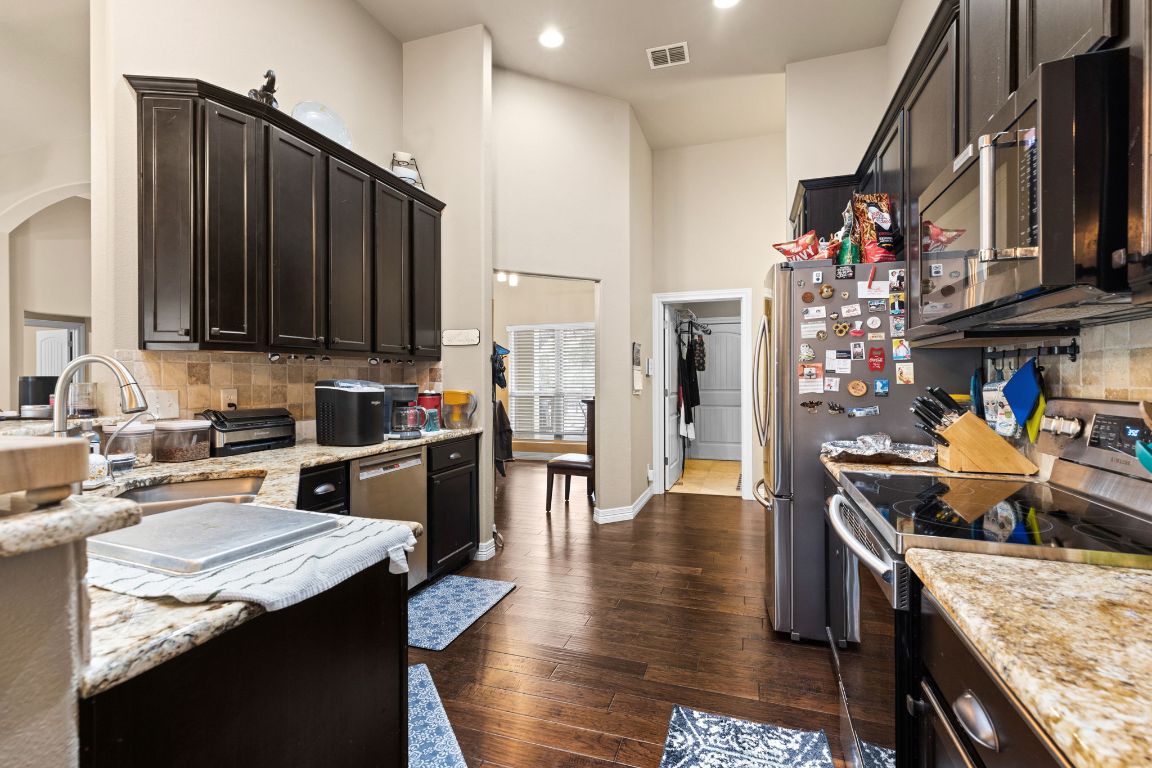 1291 Mossy Hollow Road Spring Branch, TX 78070 - Photo 7 of 23 a kitchen with stainless steel appliances granite countertop a sink stove and refrigerator