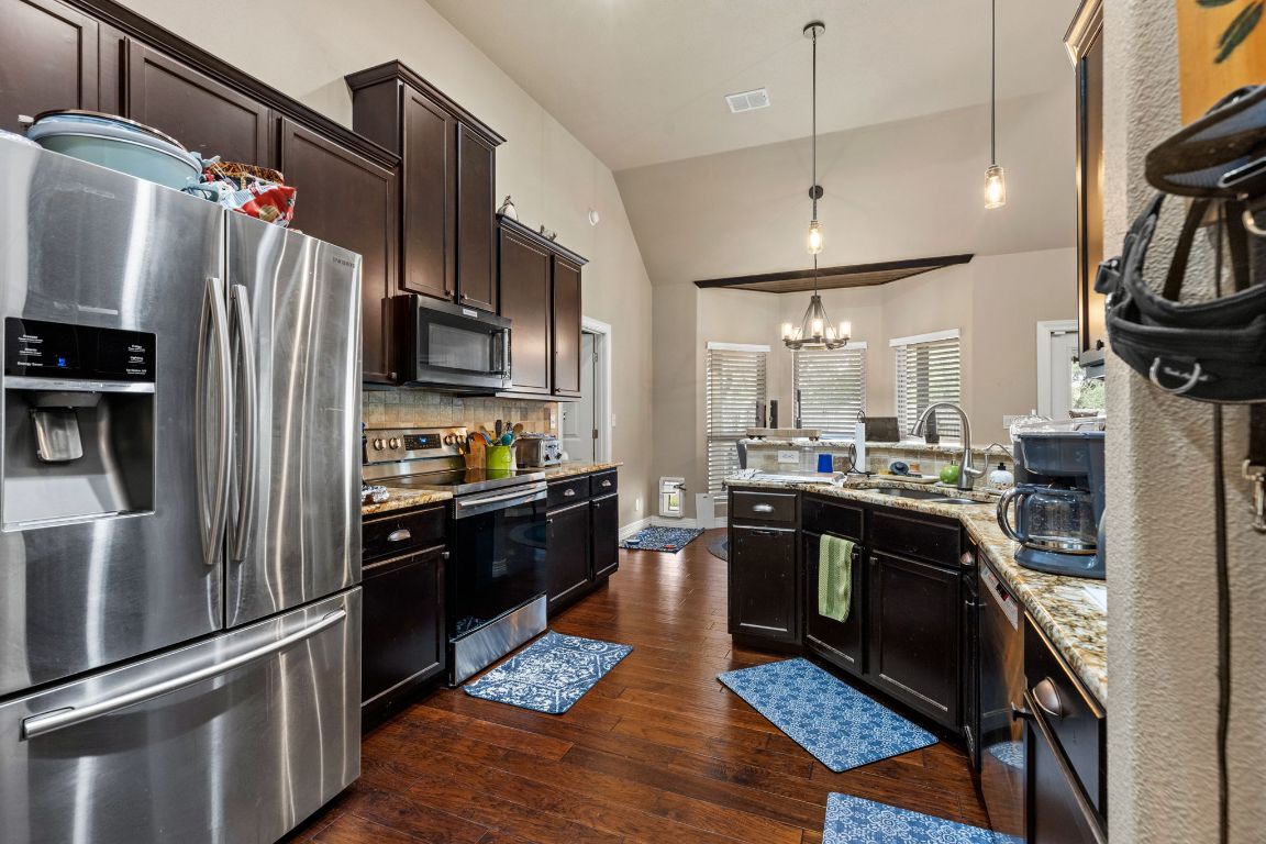 1291 Mossy Hollow Road Spring Branch, TX 78070 - Photo 8 of 23 a kitchen with stainless steel appliances granite countertop a refrigerator a stove and a sink