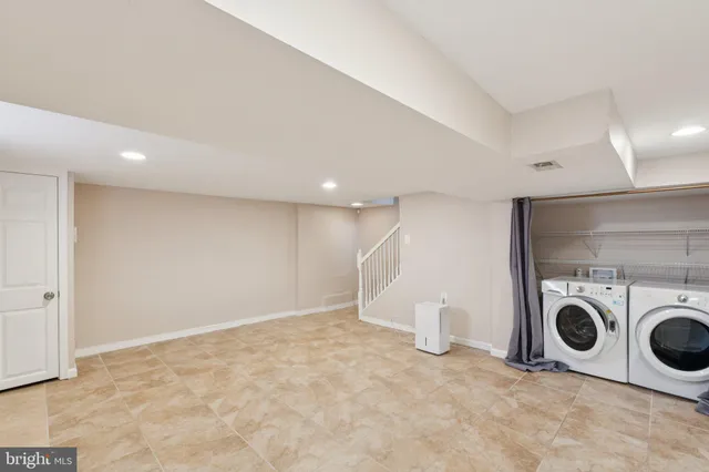 a view of a storage & utility room with two washing machine