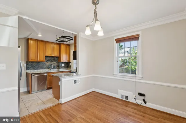 a kitchen with a refrigerator a sink and dishwasher with wooden floor
