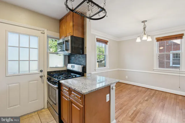 a kitchen with stainless steel appliances granite countertop a stove and a wooden floor