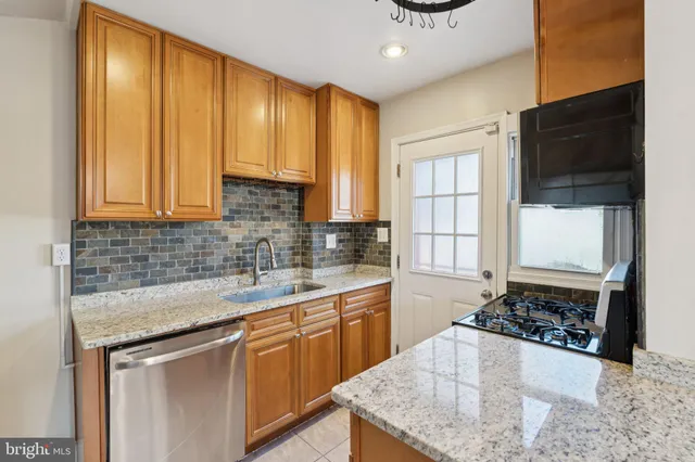a kitchen with stainless steel appliances kitchen island granite countertop a sink and a stove