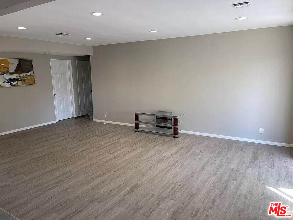 7669 Willis Avenue Van Nuys, CA 91405 - Photo 2 of 10 an empty room with wooden floor and furniture