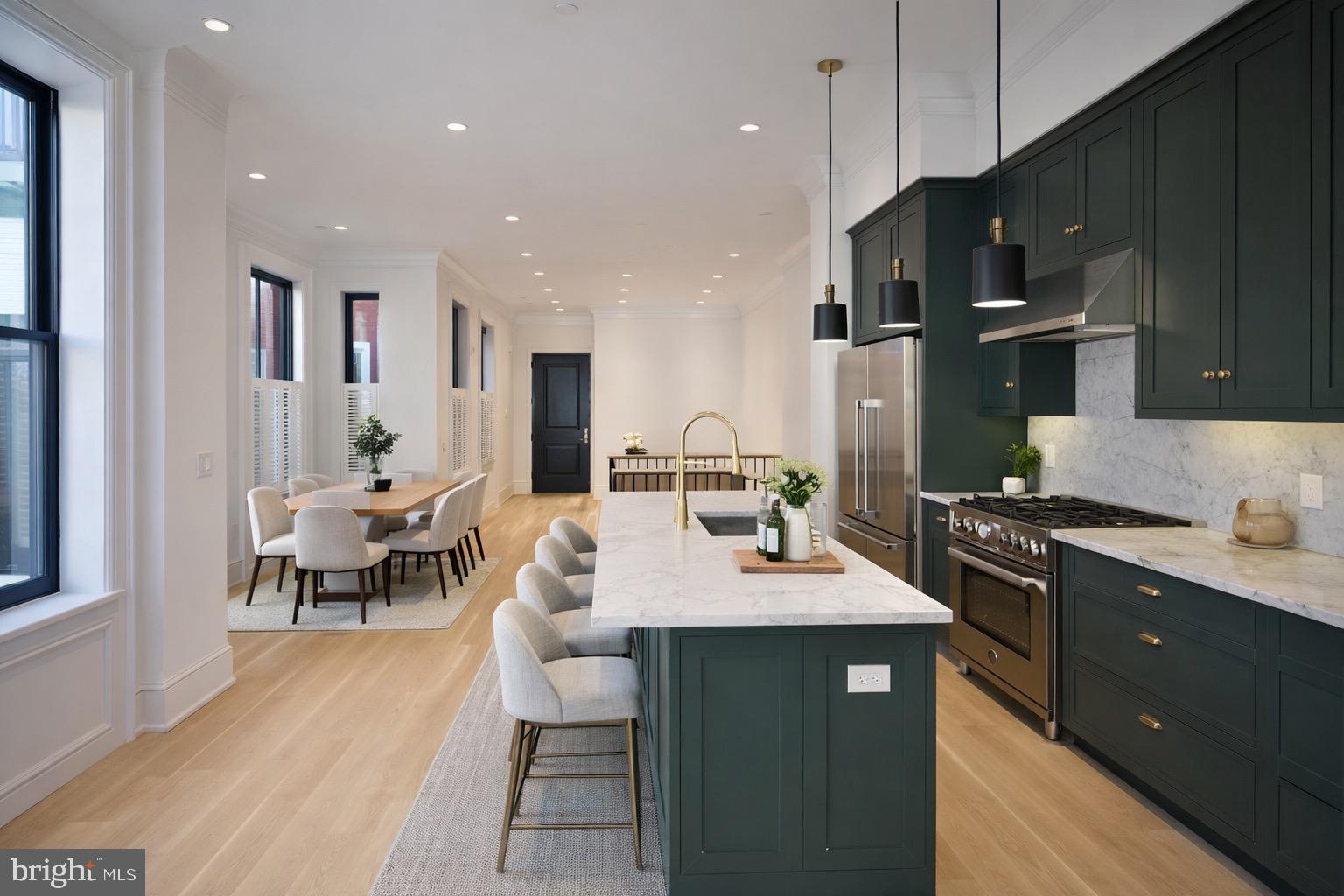 a open kitchen with stainless steel appliances granite countertop a sink dishwasher a stove a refrigerator and a dining table with wooden floor