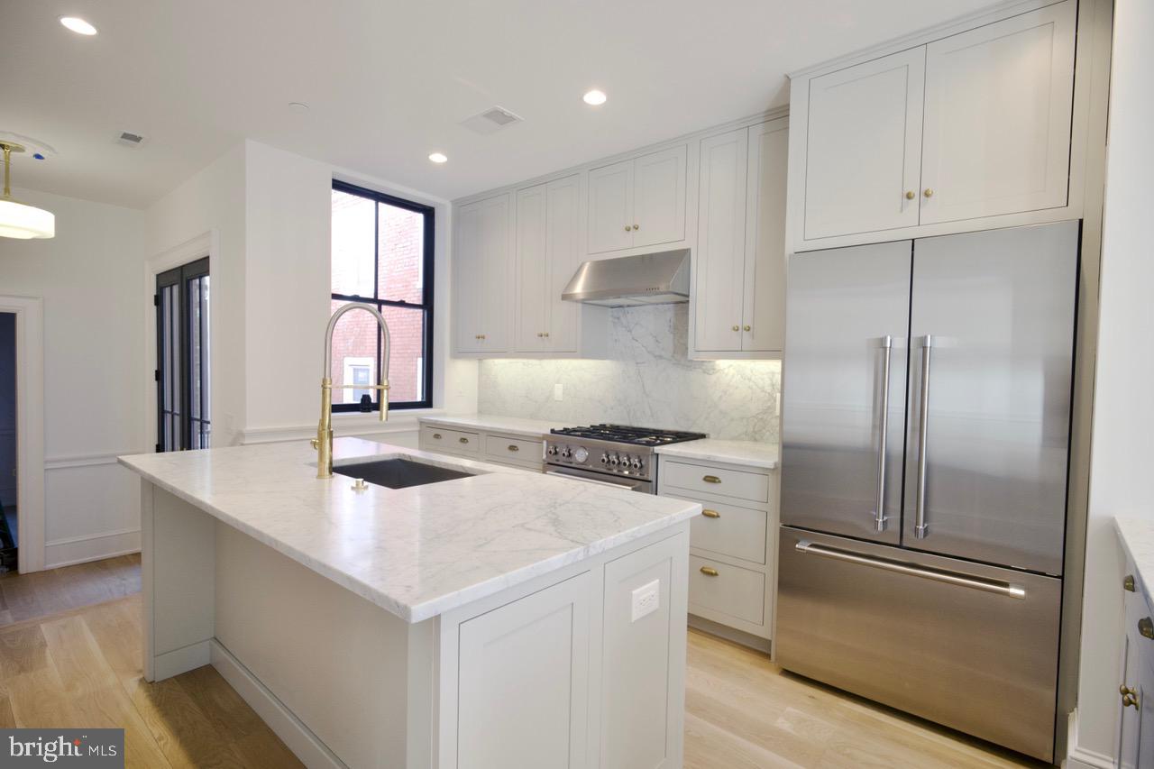 1227 North 6th Street Philadelphia, PA 19122 - Photo 13 of 32 a kitchen that has a refrigerator a sink and a stove in it