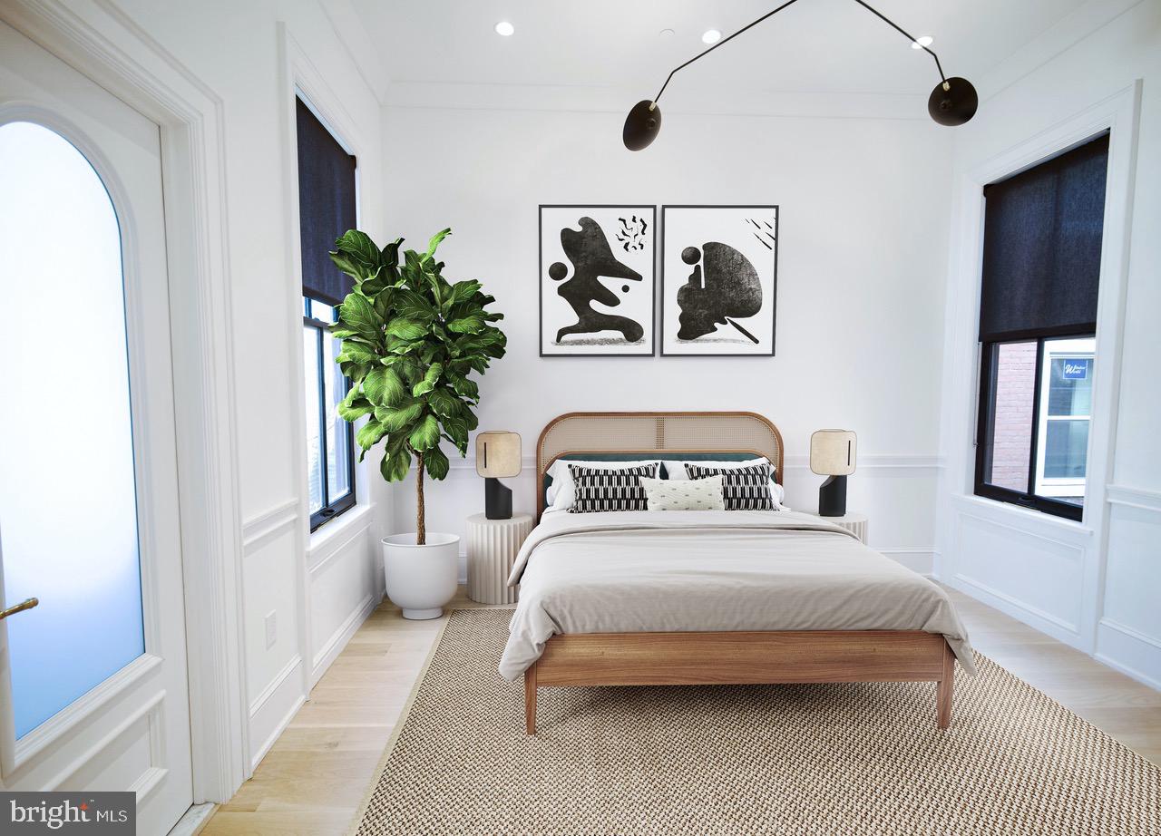 1227 North 6th Street Philadelphia, PA 19122 - Photo 15 of 32 a bedroom with a large bed and a potted plant
