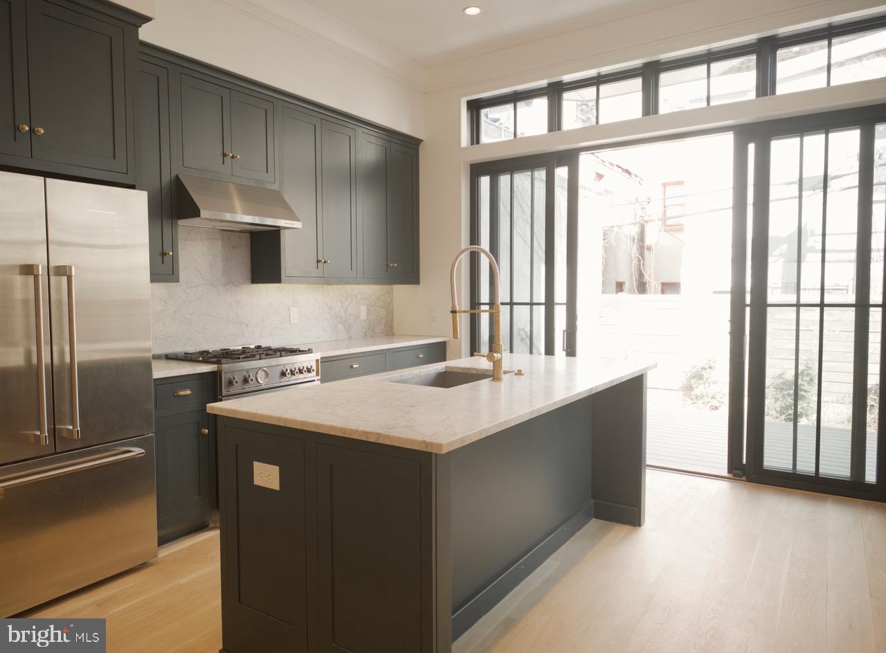 1227 North 6th Street Philadelphia, PA 19122 - Photo 20 of 32 a kitchen with stainless steel appliances granite countertop a refrigerator a sink and a stove