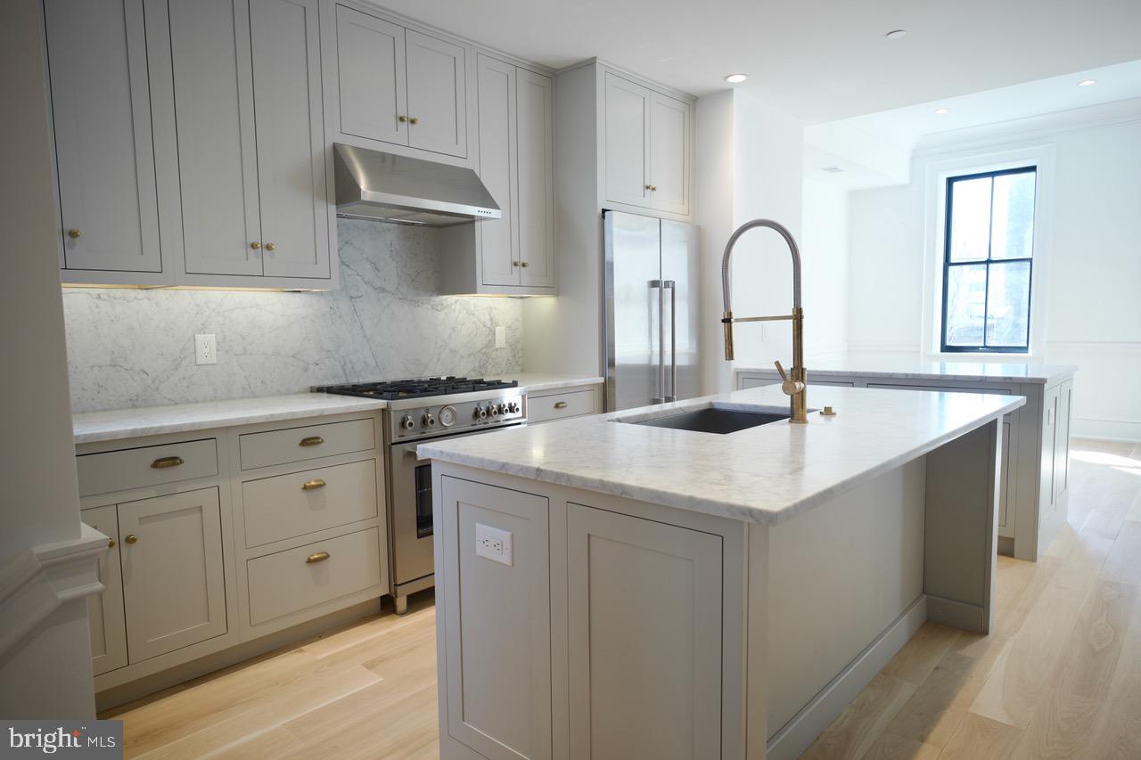 1227 North 6th Street Philadelphia, PA 19122 - Photo 9 of 32 a kitchen with granite countertop a sink a stove and cabinets