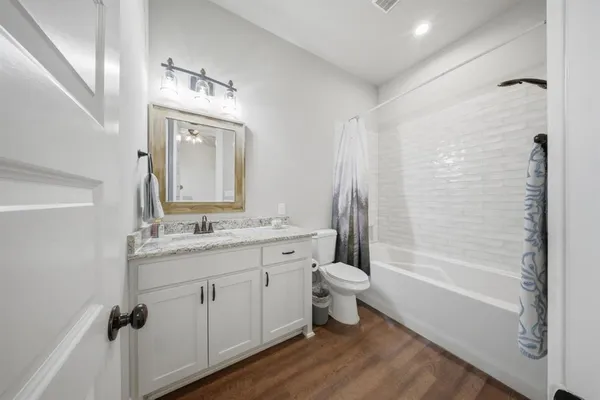 a bathroom with a granite countertop sink toilet a mirror and shower