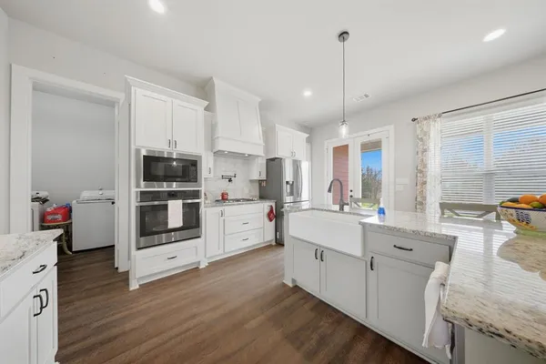 a kitchen with stainless steel appliances granite countertop a stove and a wooden cabinets