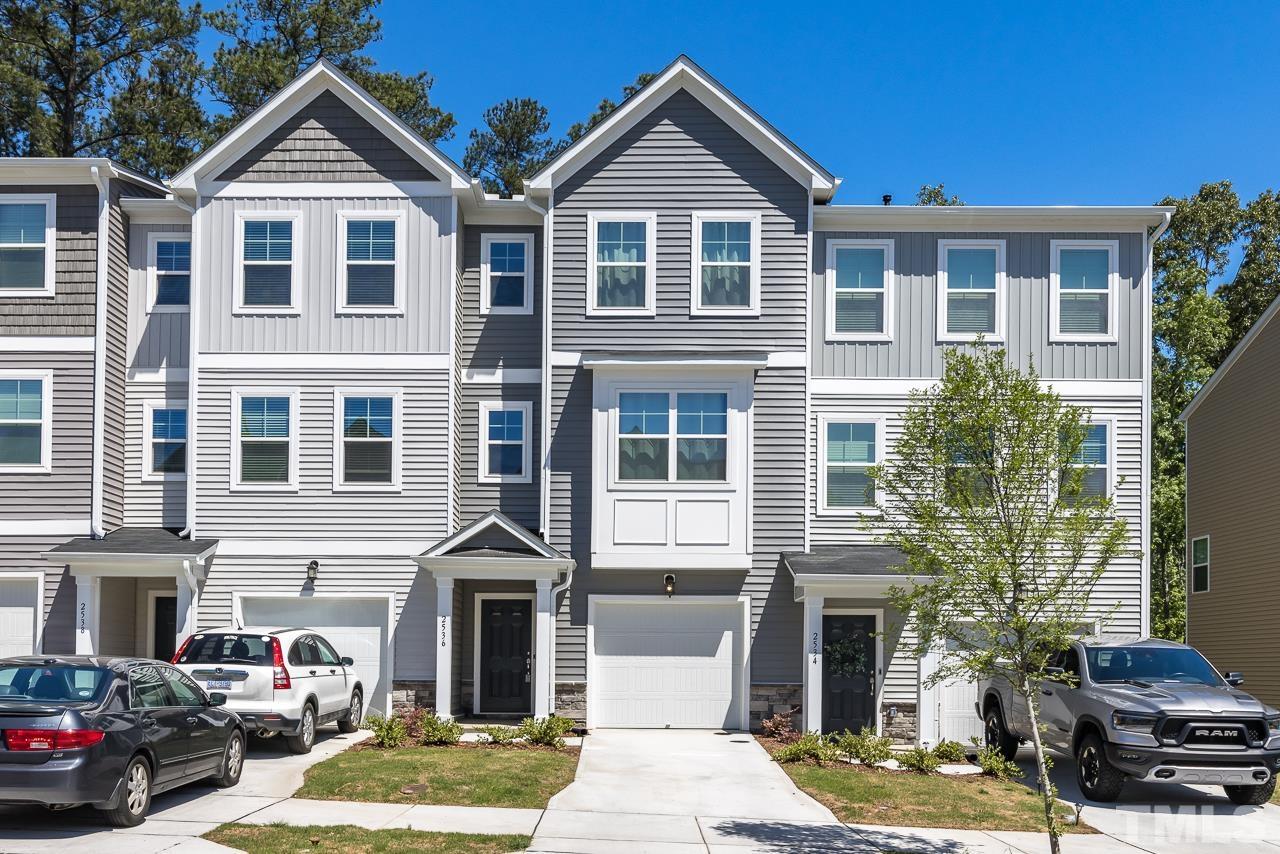 a view of a house with a yard and potted plants