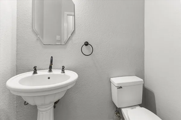 a bathroom with a toilet sink and mirror