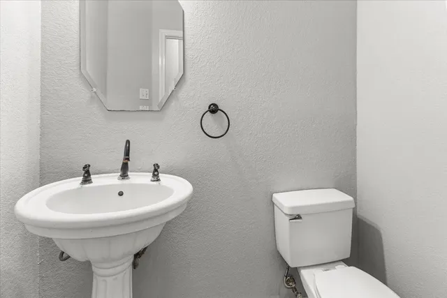 a bathroom with a toilet sink and mirror