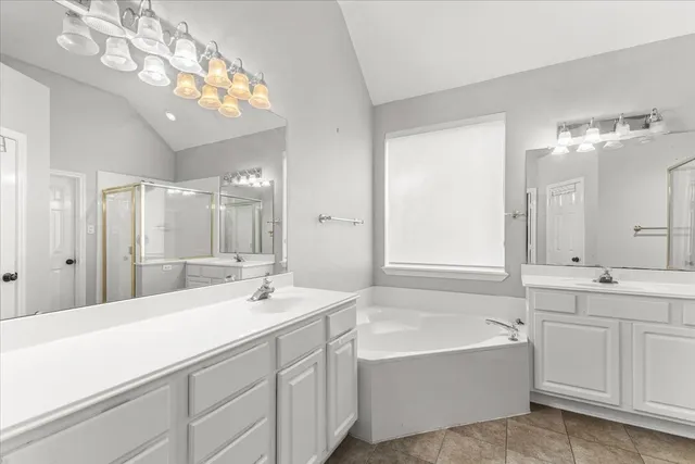 a bathroom with a bathtub a double vanity sink and a mirror