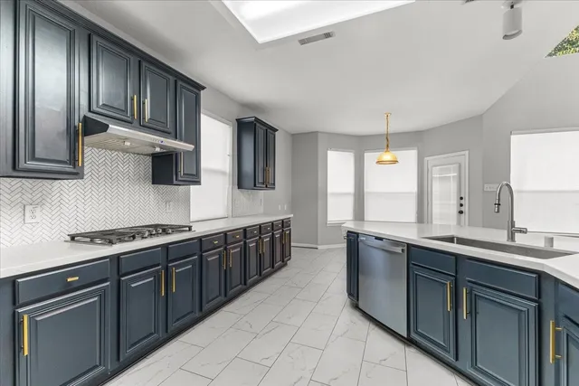 a kitchen with stainless steel appliances granite countertop a sink stove and cabinets
