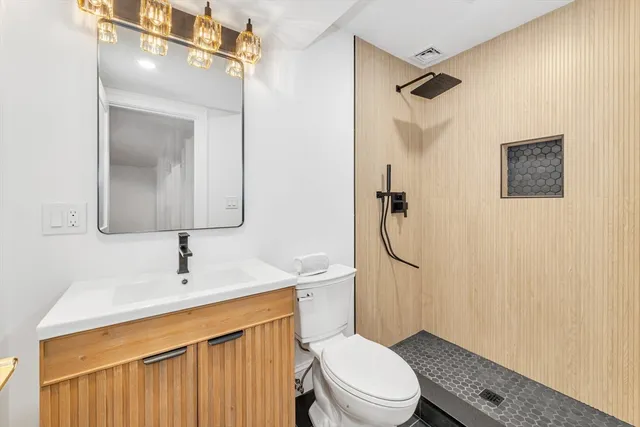 a bathroom with a sink a toilet and shower