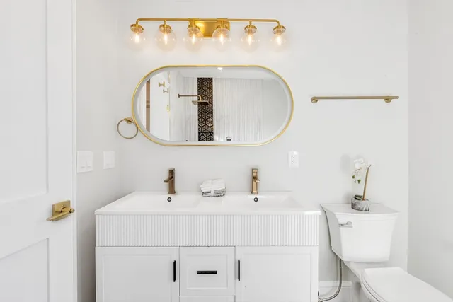 a bathroom with a toilet sink and mirror