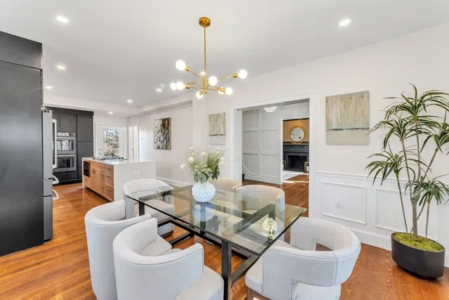 a dining room with furniture a chandelier and wooden floor