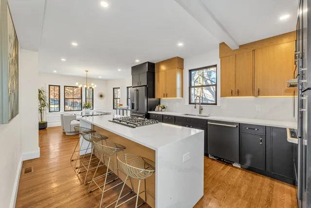 a large kitchen with kitchen island a sink table and chairs