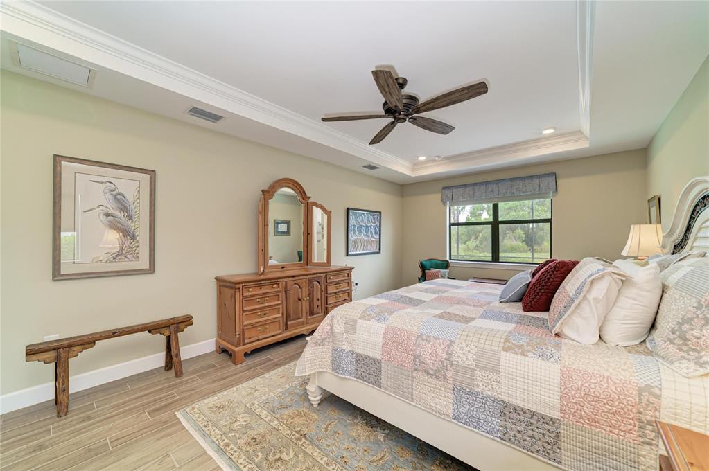 16341 Hidden Oak Loop Lakewood Ranch, FL 34211 - Photo 25 of 76 a bedroom with a large bed and a dresser