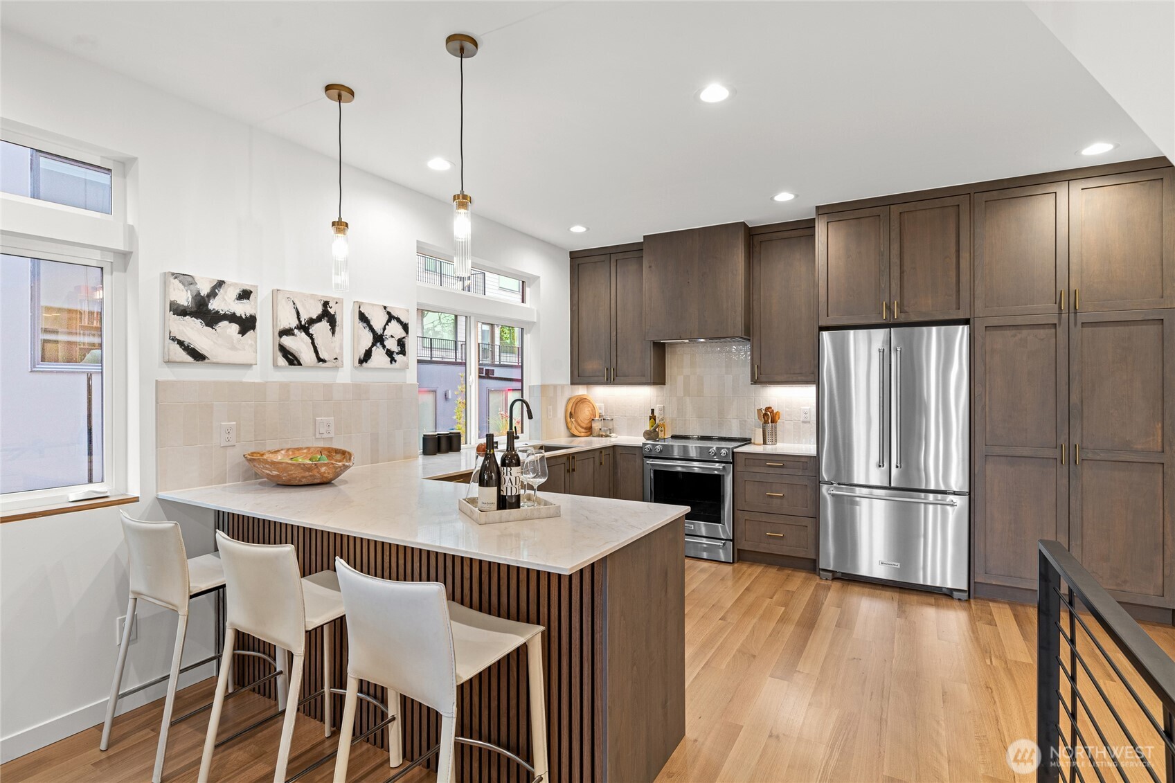 311 17th Avenue East Seattle, WA 98112 - Photo 13 of 39 a kitchen with kitchen island granite countertop a sink a refrigerator and wooden floor