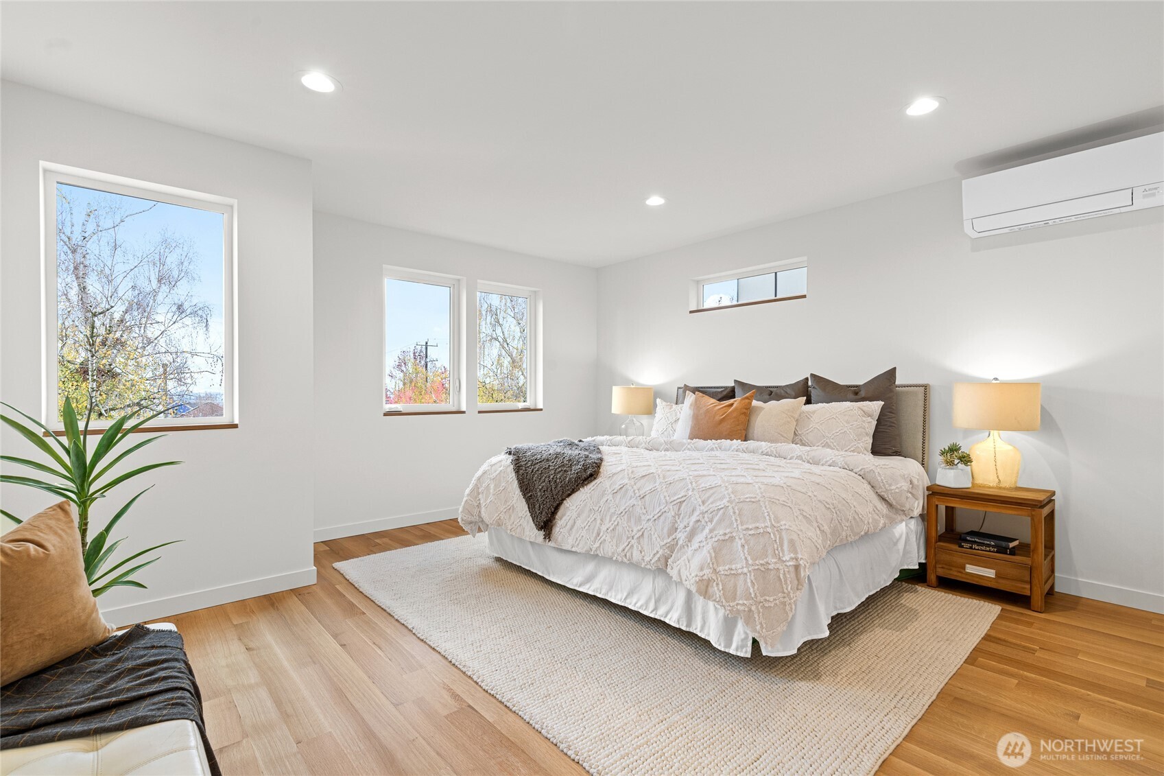 311 17th Avenue East Seattle, WA 98112 - Photo 22 of 39 a bedroom with a large bed and a potted plant on a dresser