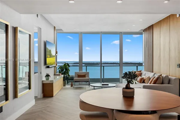 a dining room with furniture and a floor to ceiling window