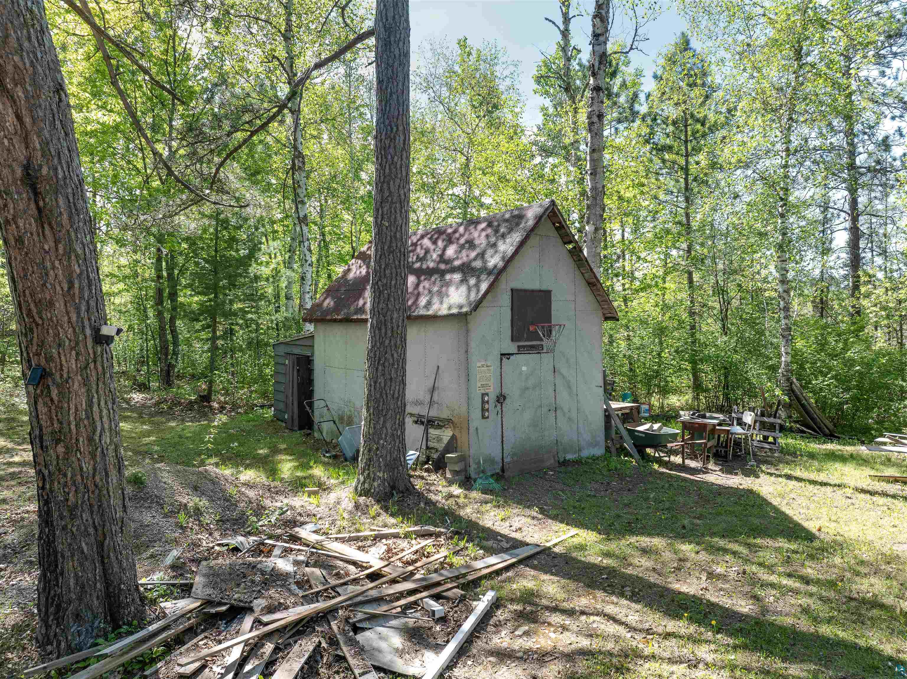 9064 Peppard Road Britt, MN 55710 - Photo 35 of 40 Wooded grounds featuring mature trees and a detached shed with an attached basketball hoop