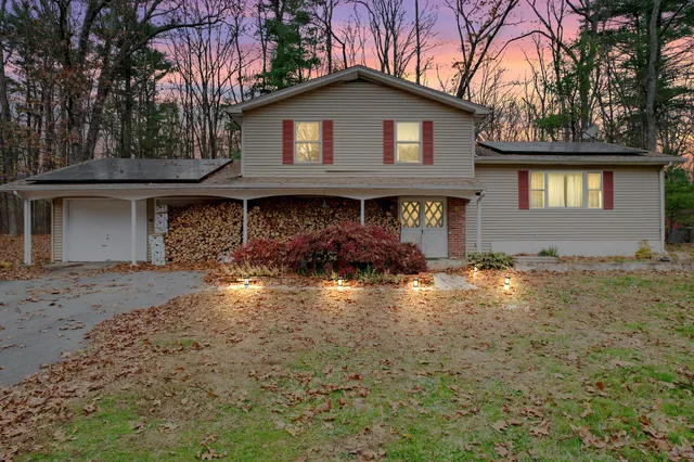 a front view of a house with yard and trees