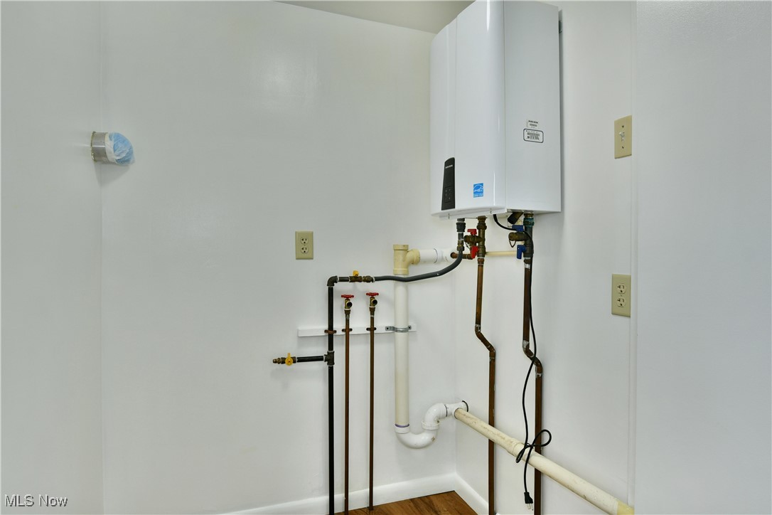 5150 Phillips Rice Road Cortland, OH 44410 - Photo 40 of 50 Laundry area featuring hookup for a washing machine, tankless water heater, and wood finished floors